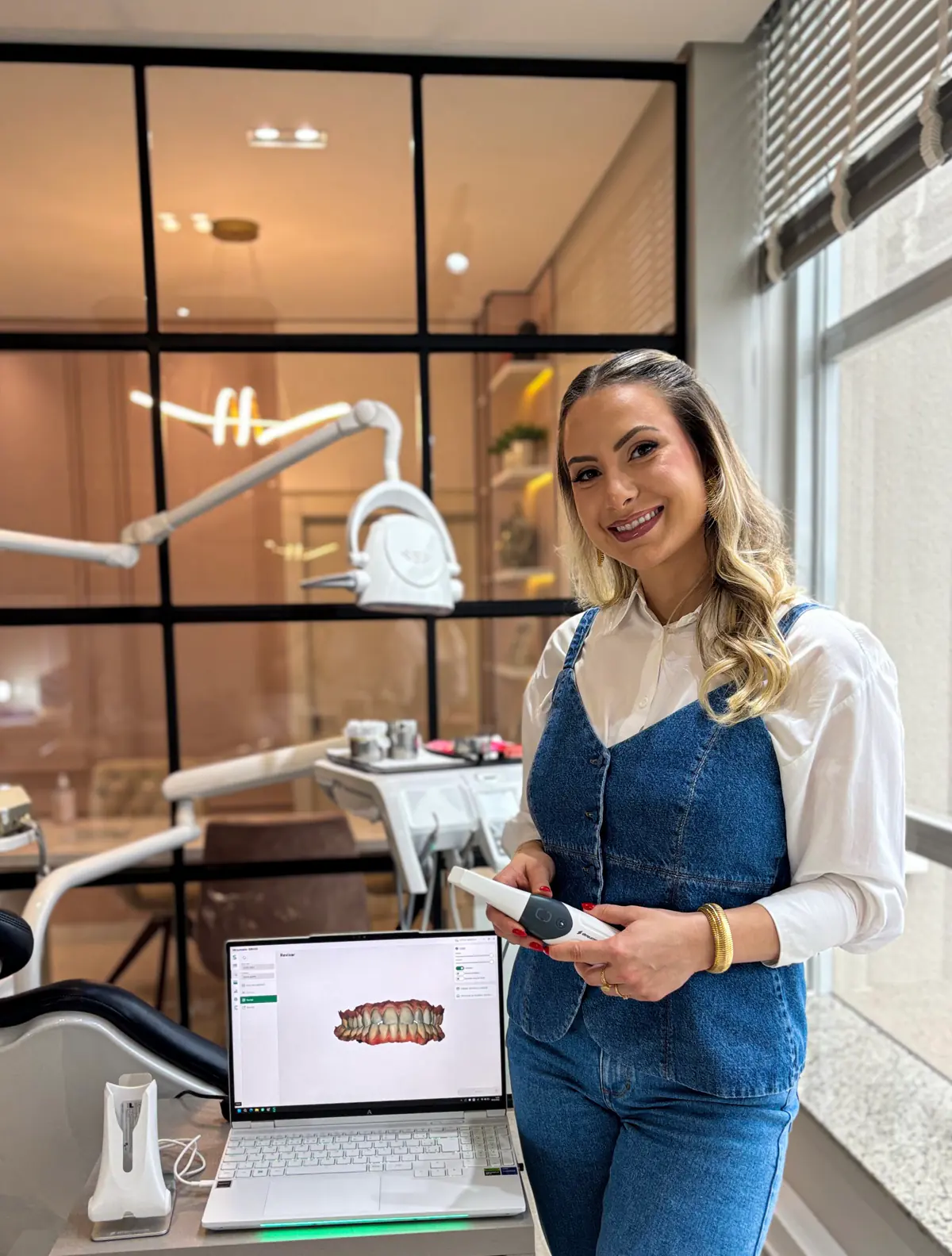 Dra. Letícia com o escâner intraoral ao lado da tela com o modelo digital dos dentes